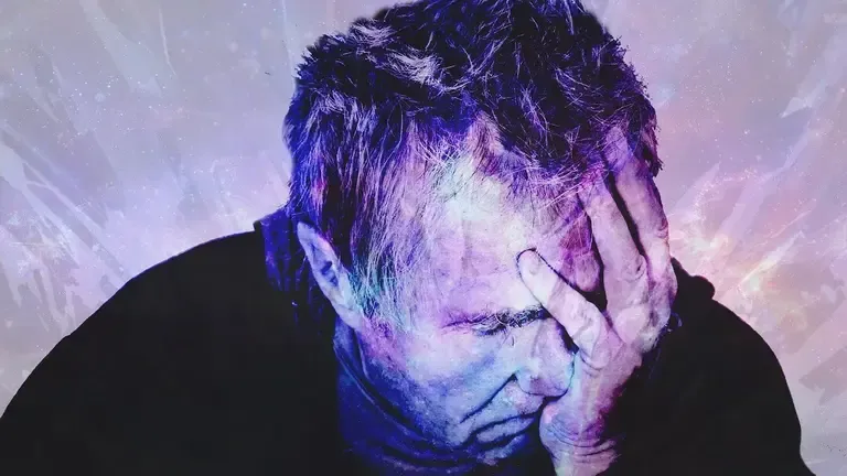 Distressed man holding his forehead with one hand against a purple cosmic textured background