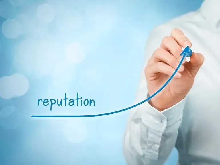Man in white shirt drawing a rising blue arrow next to the handwritten word reputation on a glass surface