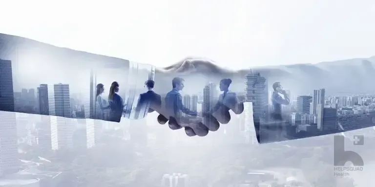 Double exposure of a business handshake over a city skyline with silhouettes of professionals in suits